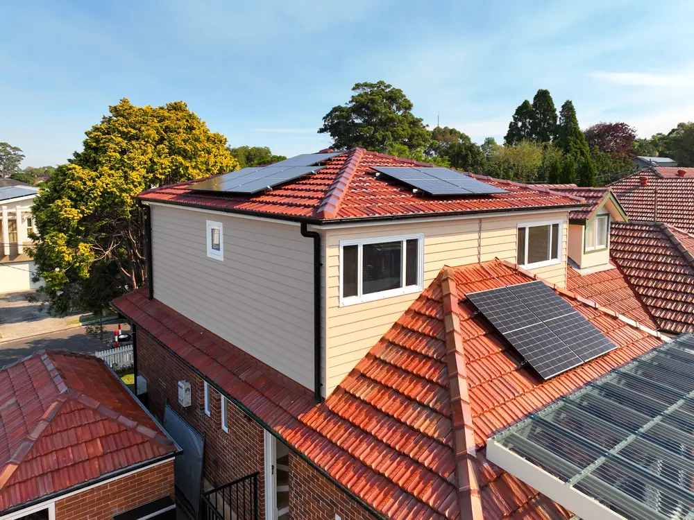Roof of the new storey with solar panels, looking across neighbouring rooftops