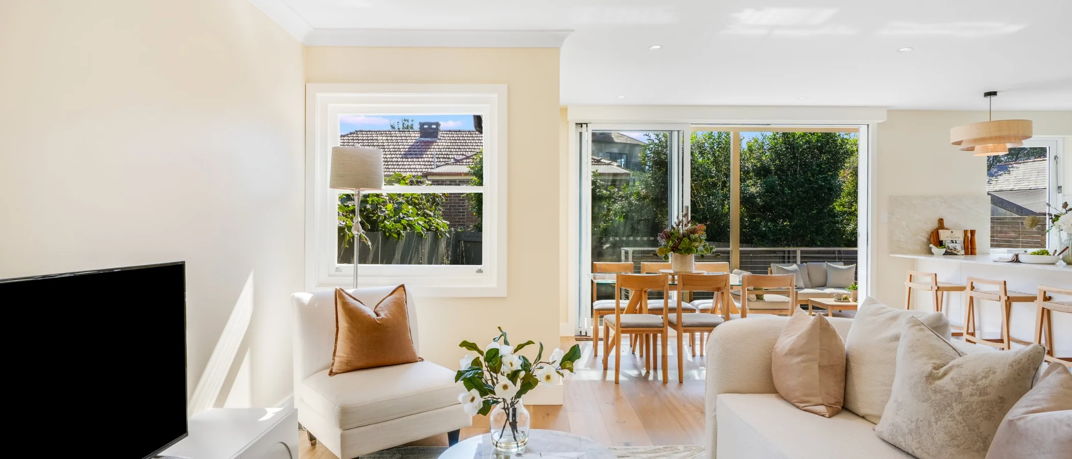 Open-plan living room looking through the dining area to the kitchen and the rear deck, 27 Forsyth Street