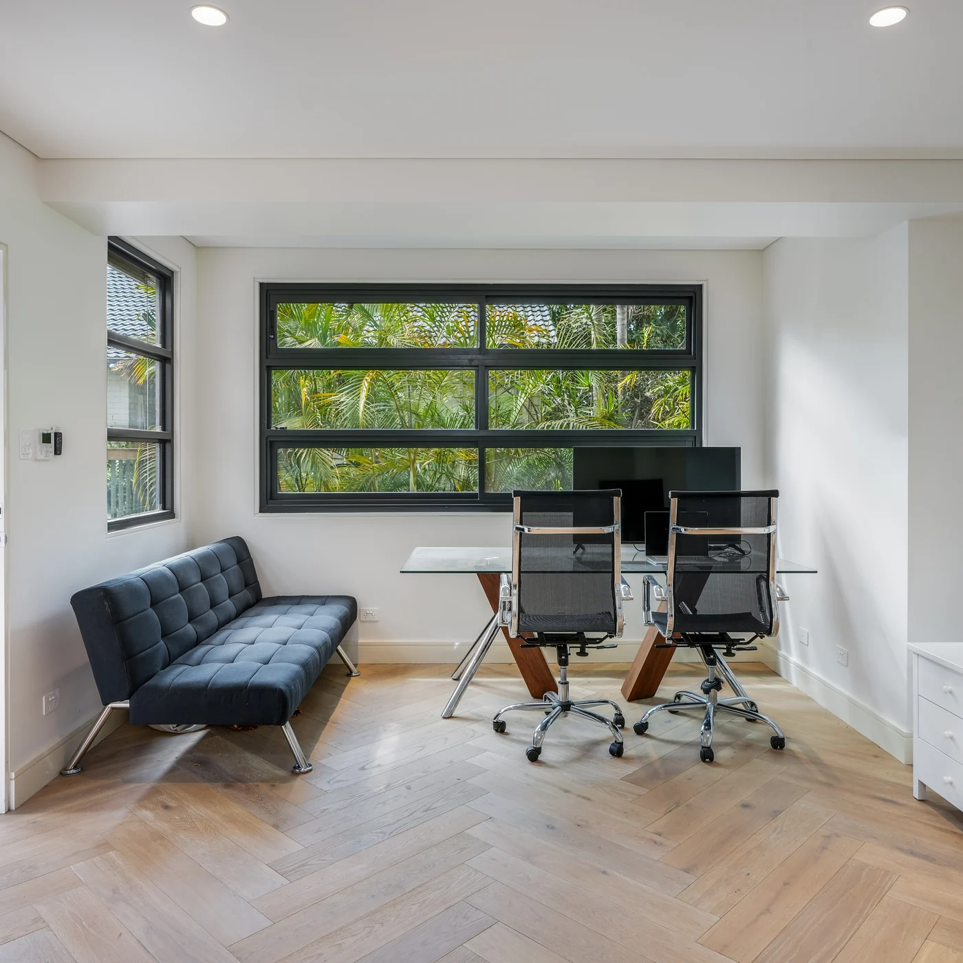 Inside the Mosman studio, herringbone parquetry and a wide window to the trees